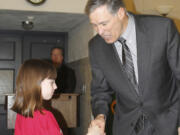 Paige Maas, a Hathaway Elementary School third-grader, shakes hands with Gov.