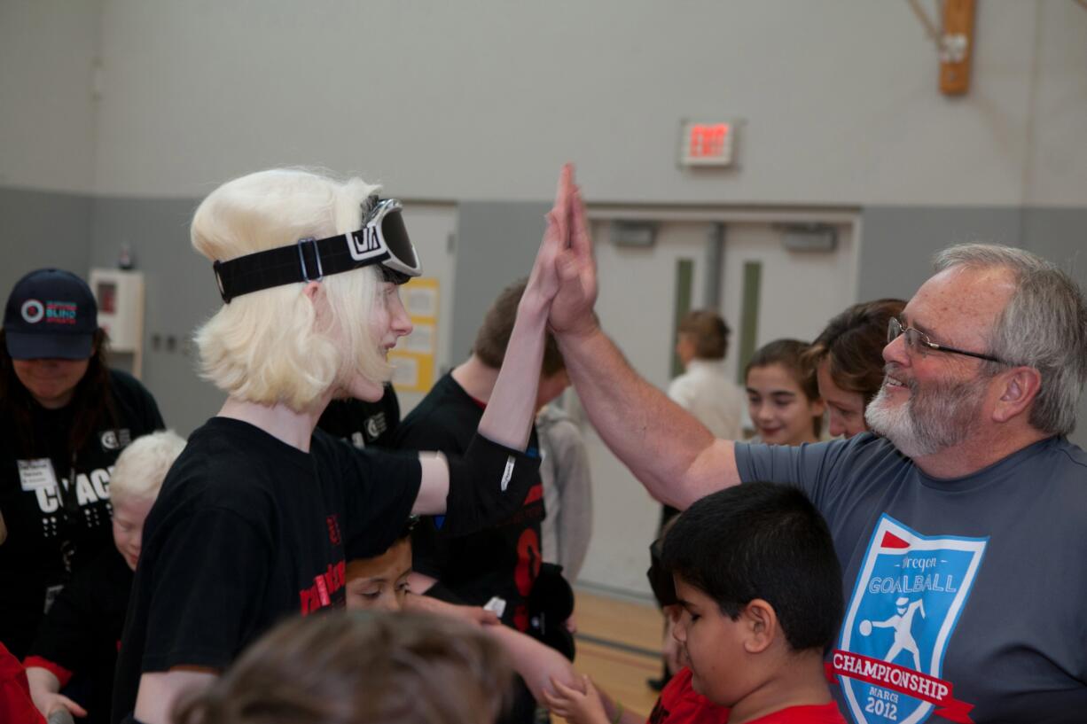 A student celebrates with a volunteer after participating in a Northwest Association of Blind Athletes goalball tournament in March, in Canby, Ore. &quot;It is a game that requires superb hearing skills, excellent reflexes and superb mental concentration,&quot; said Billy Henry, co-founder of the NWABA.