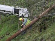 A crew member cuts down a damaged telephone pole at Milepost 21 on westbound State Route 14.