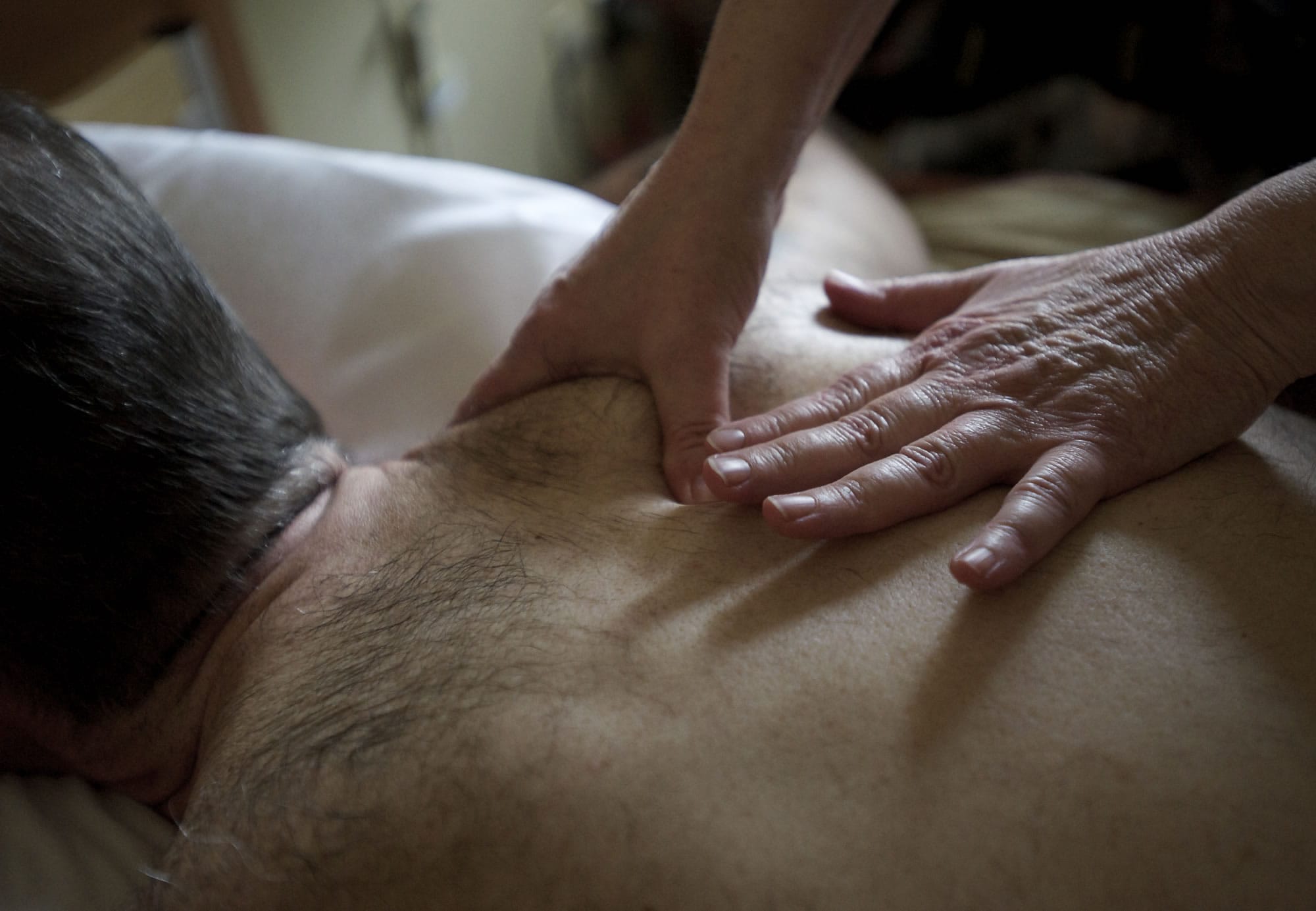 Massage therapist Debbie Switzer works with liver cancer patient Bob Garrett at the Ray Hickey Hospice House.