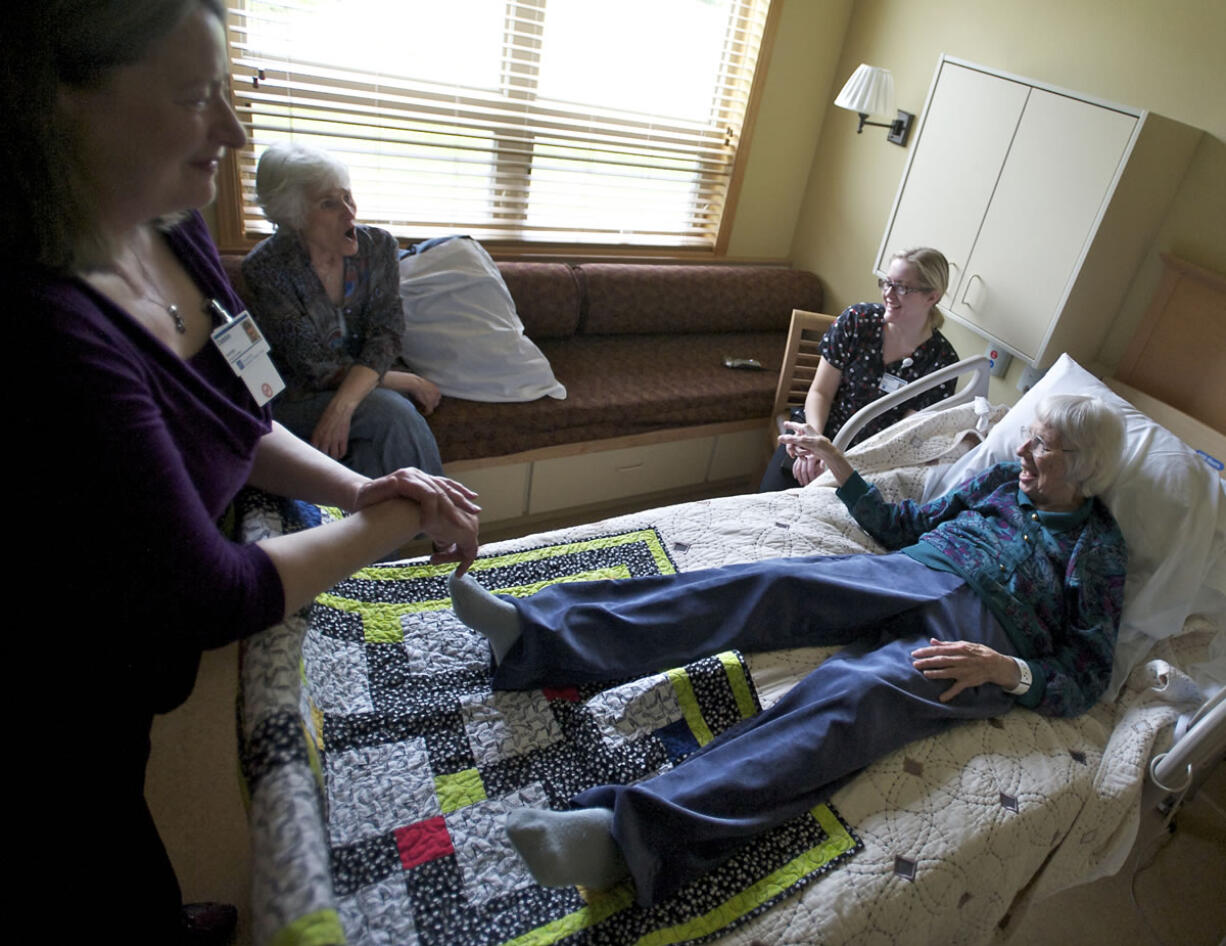 Cancer patient and Ray Hickey Hospice House resident Phyllis White, 86, recalls the good times -- and has another one -- while her fans enjoy a laugh. From left are massage therapist Debbie Switzer, a volunteer; Carol Thompson, PeaceHealth's hospice volunteer coordinator; and volunteer Beth Kellett, a registered nurse who keeps volunteering in her time off.