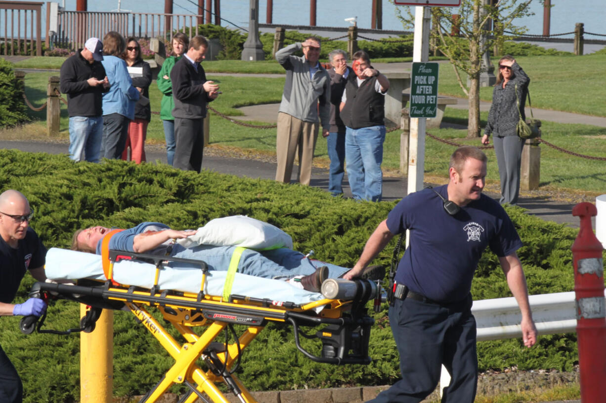 Port of Camas-Washougal employees look on as Camas-Washougal Fire Department paramedics and a volunteer &quot;victim&quot; takes part in this morning's emergency drill.