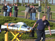 Port of Camas-Washougal employees look on as Camas-Washougal Fire Department paramedics and a volunteer &quot;victim&quot; takes part in this morning's emergency drill.