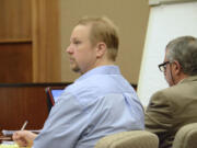 Troy Fisher, left, accused of killing his father, listens to testimony from a prosecution witness Tuesday in his trial in front of Clark County Superior Court Judge Barbara Johnson.