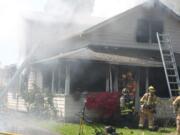 Emergency crews work to put out a house fire at 1524 S.E. Seventh Ave., in Camas. Firefighters from Camas, Washougal and East County Fire and Rescue were dispatched at approximately 11:30 a.m.