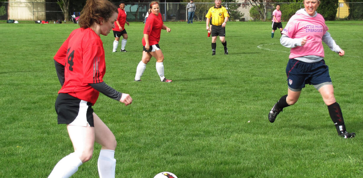 Erin Bradstreet, of Camas, moves the ball down the field, as her sister Rachel (center), of Washougal, looks on. The Bradstreets and their teammates on Passin Thru beat the team Little Indian 4-2, on April 13, at Wy'East Community Park, in Vancouver.