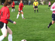 Erin Bradstreet, of Camas, moves the ball down the field, as her sister Rachel (center), of Washougal, looks on. The Bradstreets and their teammates on Passin Thru beat the team Little Indian 4-2, on April 13, at Wy'East Community Park, in Vancouver.