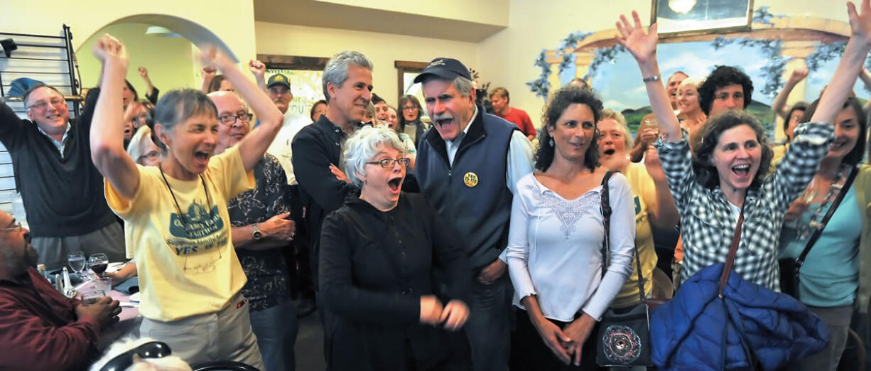 Measure 15-119 supporters react after learning that Roughly 66 percent of Jackson County voters favored banning GMO crops in the first round of election results released tonight while gathered at Capers Restaurant in Medford Ore. on May 20, 2014.