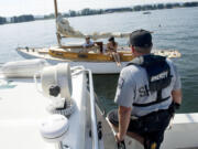 Clark County Sheriff's Deputy Todd Baker talks with boaters in August 2011 about missing registration numbers on a sailboat they were using for the day.