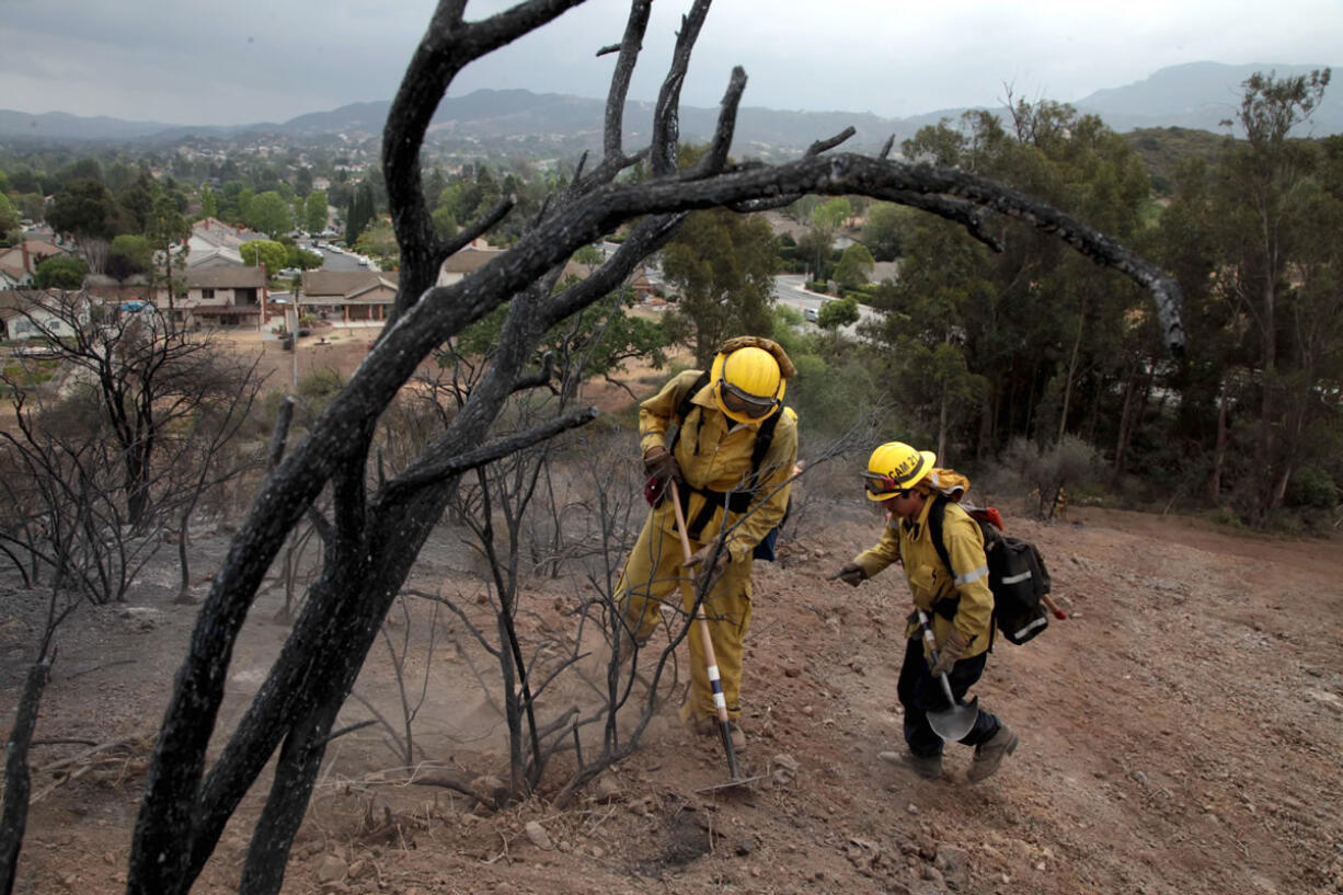 Crews inspect burned areas Sunday in Newbury Park, Calif.