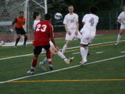 Camas forward Cameron Eyman kicks the soccer ball between three defenders and out of reach of the goalkeeper Thursday, at McKenzie Stadium.