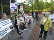 Protesters opposed to the hiring of State Sen. Don Benton stand outside the Clark County Public Services Center on Tuesday.