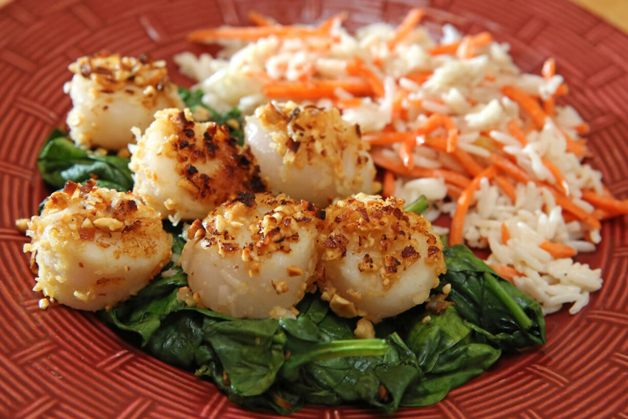 Peanut-crusted scallops with coconut-carrot rice topped on bed of spinach make for a quick meal.