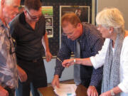 Rand Thornsley (second from left), managing director of The Rootstock Capital Management LLC, prepares to sign a five-year lease with Gary and Marilyn Webberley, owners of the Liberty building through Fourth Avenue Liberty LLC. Greg Goforth (second from right), a commercial real estate broker with Coldwell Banker Commercial, Jenkins &amp; Associates, represented both parties. Thornsley plans to offer 3D presentations this summer and open an ice cream and sandwich shop next to the theater in July. He hopes to apply for a beer and wine license in June and start serving by Oct. 1.