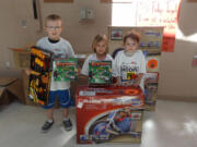 Third-grader Brian Hoff, kindergartner Addysen Case and first-grader Davlin Coburn proudly display the prizes they won for being top fundraisers during the Hoops for Heart event at Lacamas Heights Elementary School. A total of $10,925 was raised for the American Heart Association. Of that total, Coburn was the top fundraiser at $1,205.