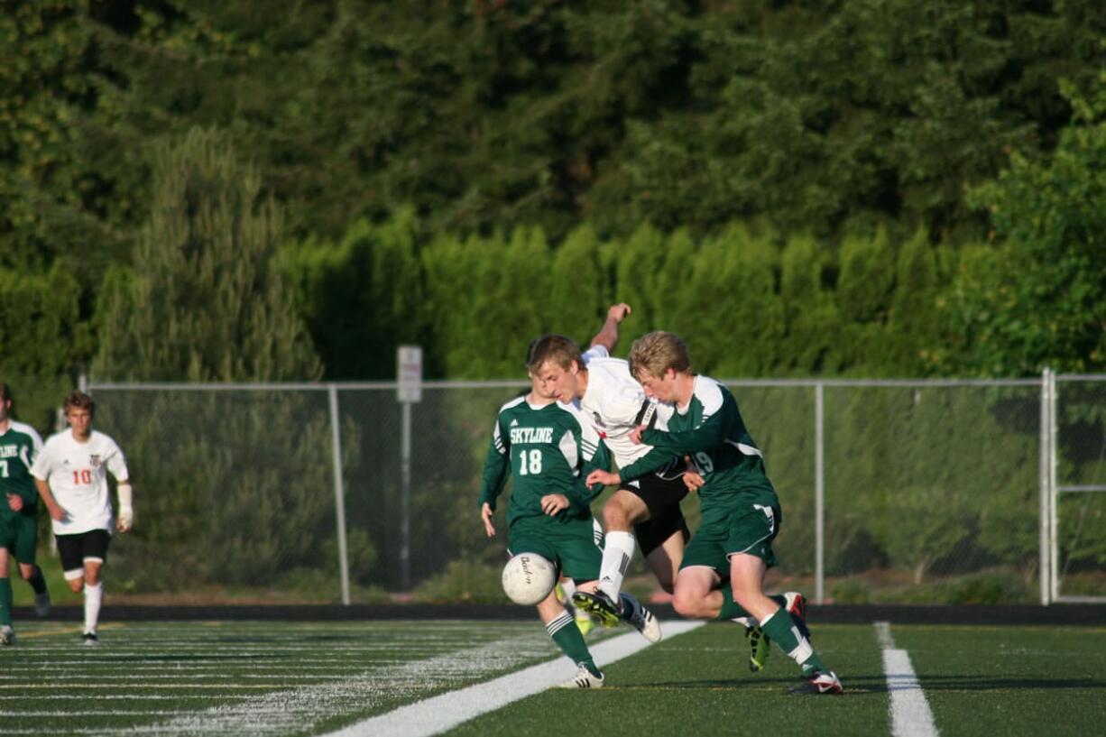 Camas forward Nate Beasley bursts through two Skyline Spartans May 14, at Doc Harris Stadium.