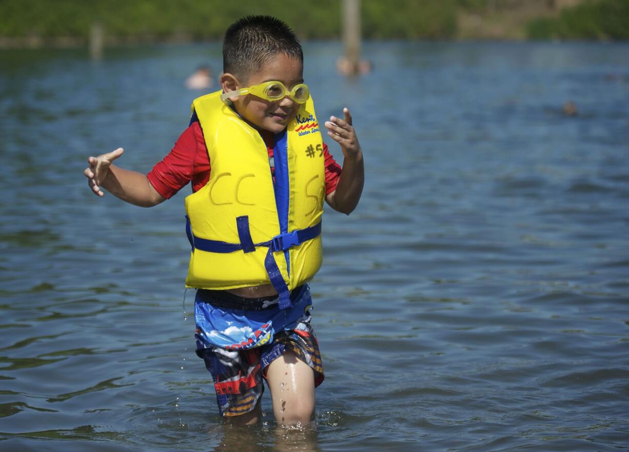 Esteban Cervantes, of Vancouver, wears a life vest while swimming at Klineline Pond in July 2012.