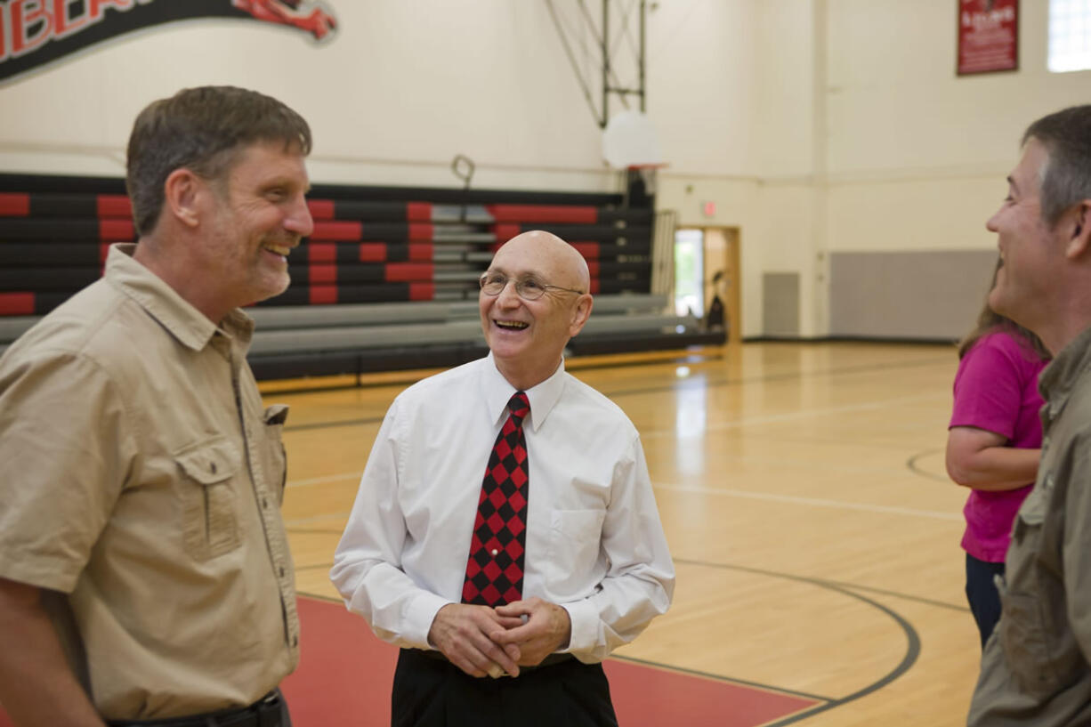 Former colleagues and friends share laughs with Charlie Hinds (center) during a community gathering event Saturday, at Liberty Middle School.