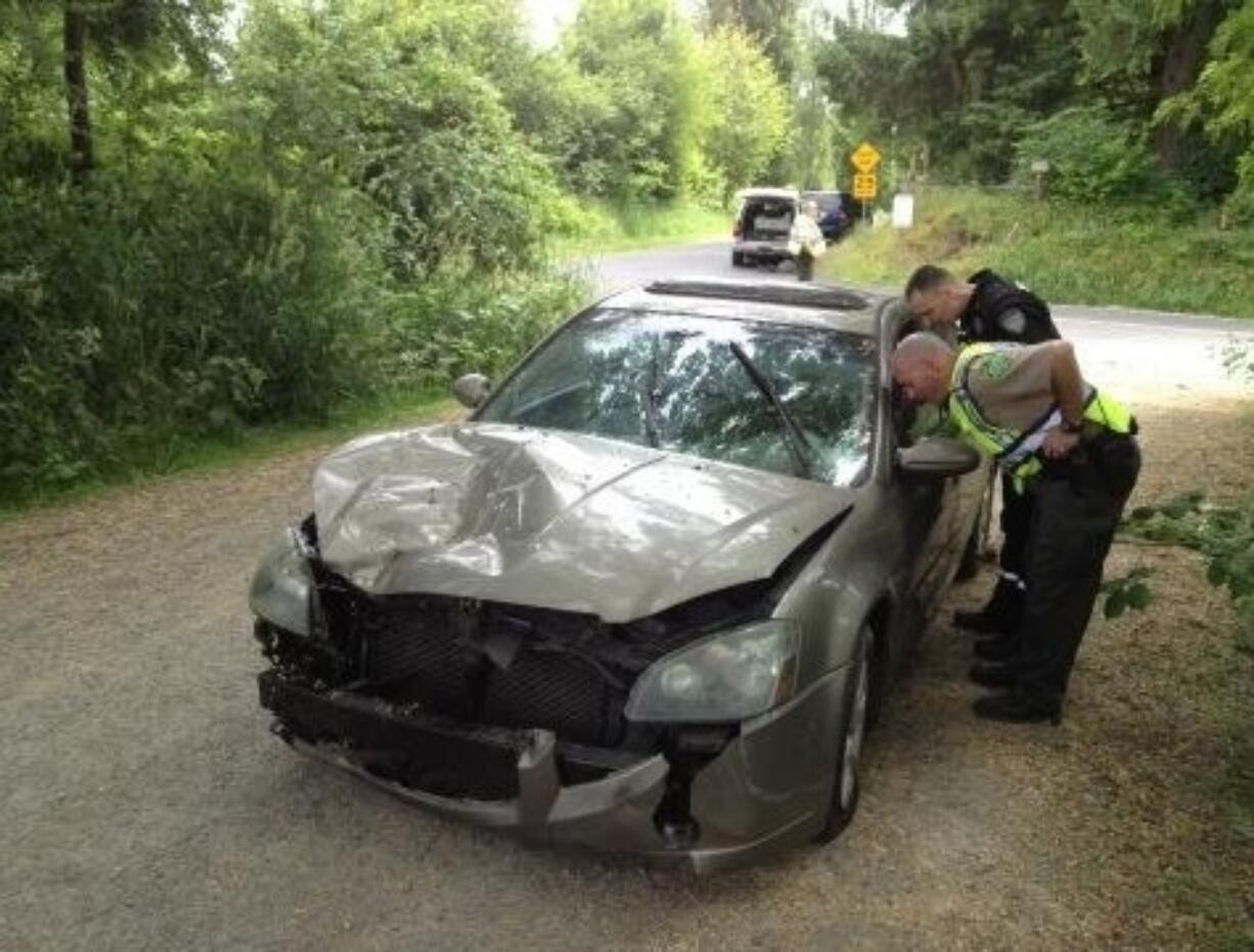 Detectives with the Clark County Sheriff's office investigate a car accident Monday that significantly injured Battle Ground High School student Justin Carey, 16.