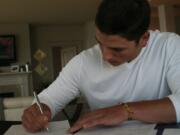 Camas pitcher Taylor Williams puts pen to paper on a $400,000 Major League Baseball contract with the Milwaukee Brewers Monday.