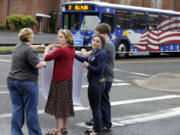 Brooklyn Newcomb, second left, the sister of Benjamin Fulwiler, assisted by Jennie Stanavech, left, blocks a C-Tran bus with a rope during a vigil on what would have been his 12th birthday.