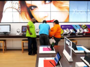 Employees Rico Price, from left, Matt Bastien and Bebe Gonzalez set up displays at a new Microsoft Store in St.