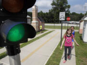 Paul Tople/Akron Beacon Journal
Nickolas Fenwick, 6, far left, his sister Madison Fenwick, 9, and Alyssa Walter, 8, right, practice following the sidewalk and traffic safety rules as they learn the safe way to walk to school at the Safety Village Playground at the Stow, Ohio, Fire Department.