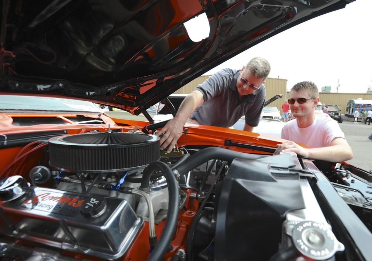 Car lovers, including Roy Rhine and son Trevor with his '68 Pontiac Firebird, gather Sunday at Pied Piper Pizza in Orchards for the annual Father's Day Cruise-in to benefit the Relay for Life cancer effort.