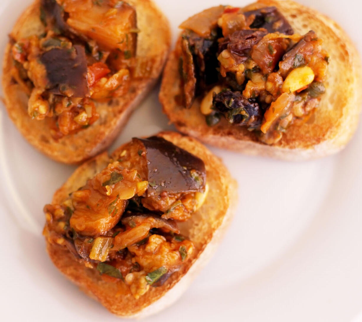 Eggplant caponata on toasted baguette slices.