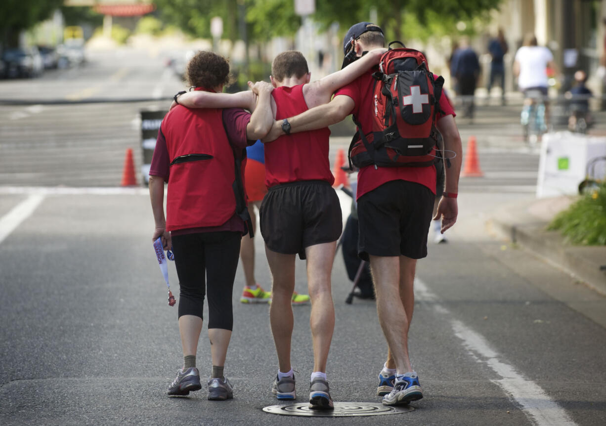 Exhausted after finishing third in the Vancouver USA Marathon in 2:49:29, San Francisco's David Kyle, 34, is aided by medical attendants.