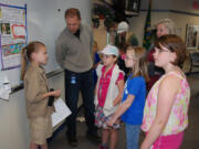 Gause Elementary second-grader Susie Liston shares information she has learned about Jane Goodall with Darren Taie and students (left to right) Emma Gorham, Caitlyn Bailey and Abigail McBride.