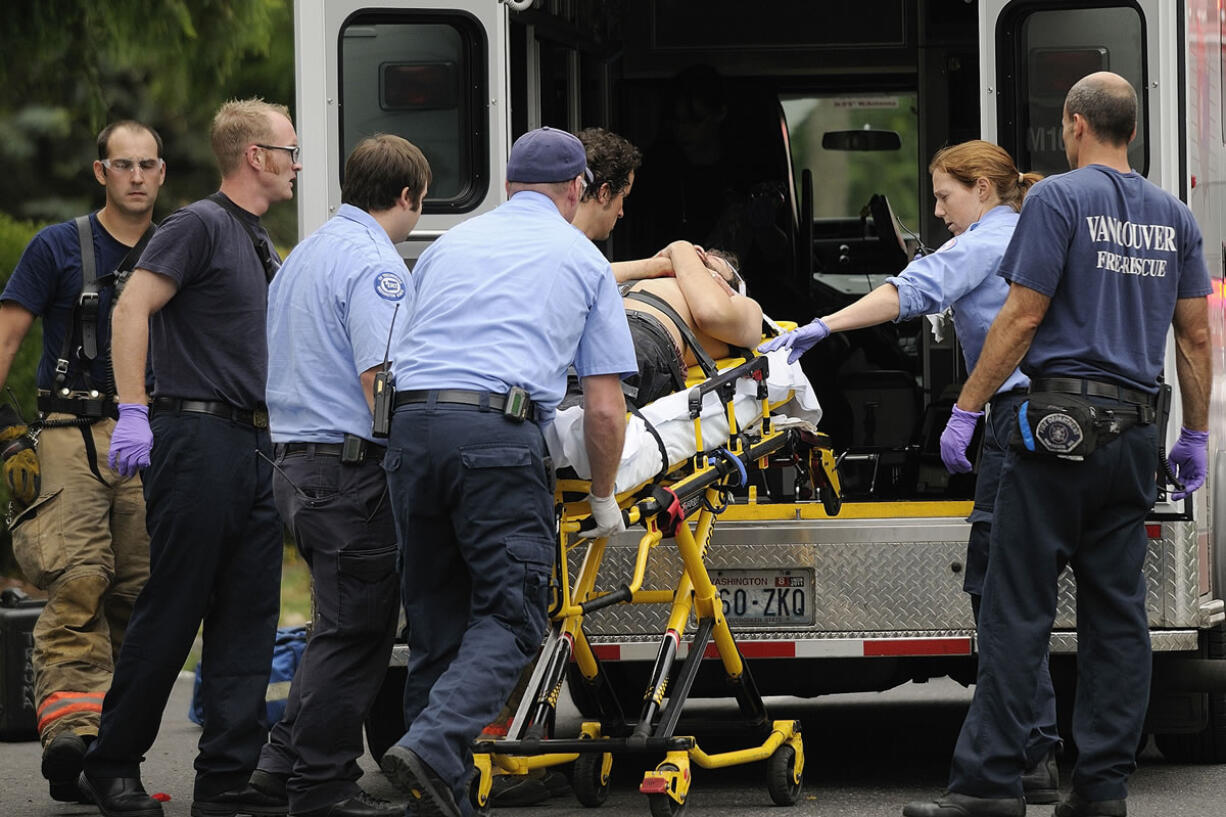 Vancouver paramedics rush a shooting victim into an ambulance on East McLoughlin Boulevard in September 2010.