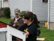 Marissa Stevens of Washougal and Payden Thornton of Ridgefield put shingles on a play house at Second Step housing.