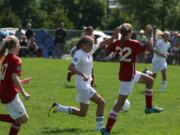 Perri Belzer (left) of the Vancouver Timbers 99 Red takes on a defender from the Camas-Washougal Soccer Alliance Valencia in the U-13 Platinum championship game of the Clash at the Border tournament.