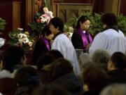 Jing Jianmei, facing camera, right, a pastor at the Hongde Tang Church in Shanghai, China, leads a Sunday worship service on March 3, 2013. Hongde Tang is one of about 25 official Christian churches in Shanghai.