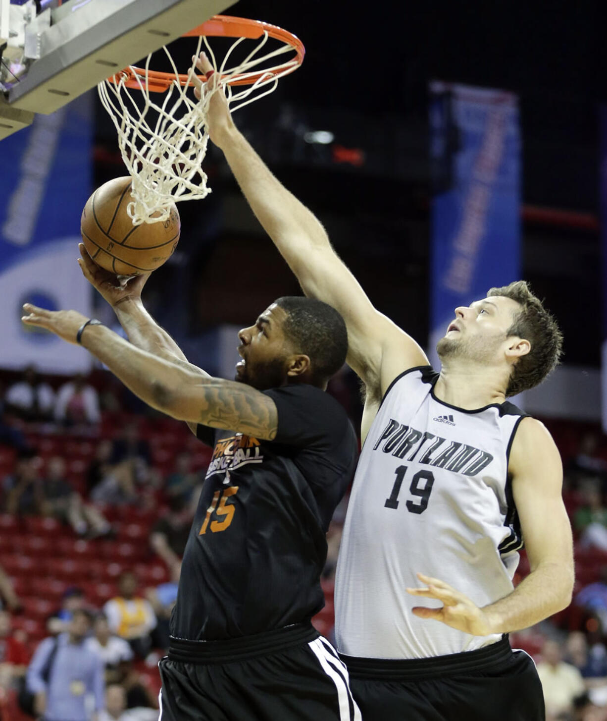 Portland's Joel Freeland (19) defends against Marcus Morris of Phoenix during Saturday's Summer League game in Las Vegas.