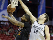 Portland's Joel Freeland (19) defends against Marcus Morris of Phoenix during Saturday's Summer League game in Las Vegas.