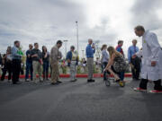 Mary Handy of Washougal takes a dare to ride a mini bicycle from Henrik Bothe, right, who was hired to keep a the crowd entertained at a New Seasons job fair at Life Point Church in September. Handy, who moved to the area from Idaho to be closer to family, quit her job at a convenience store when she moved two months ago and has been looking for a new job.