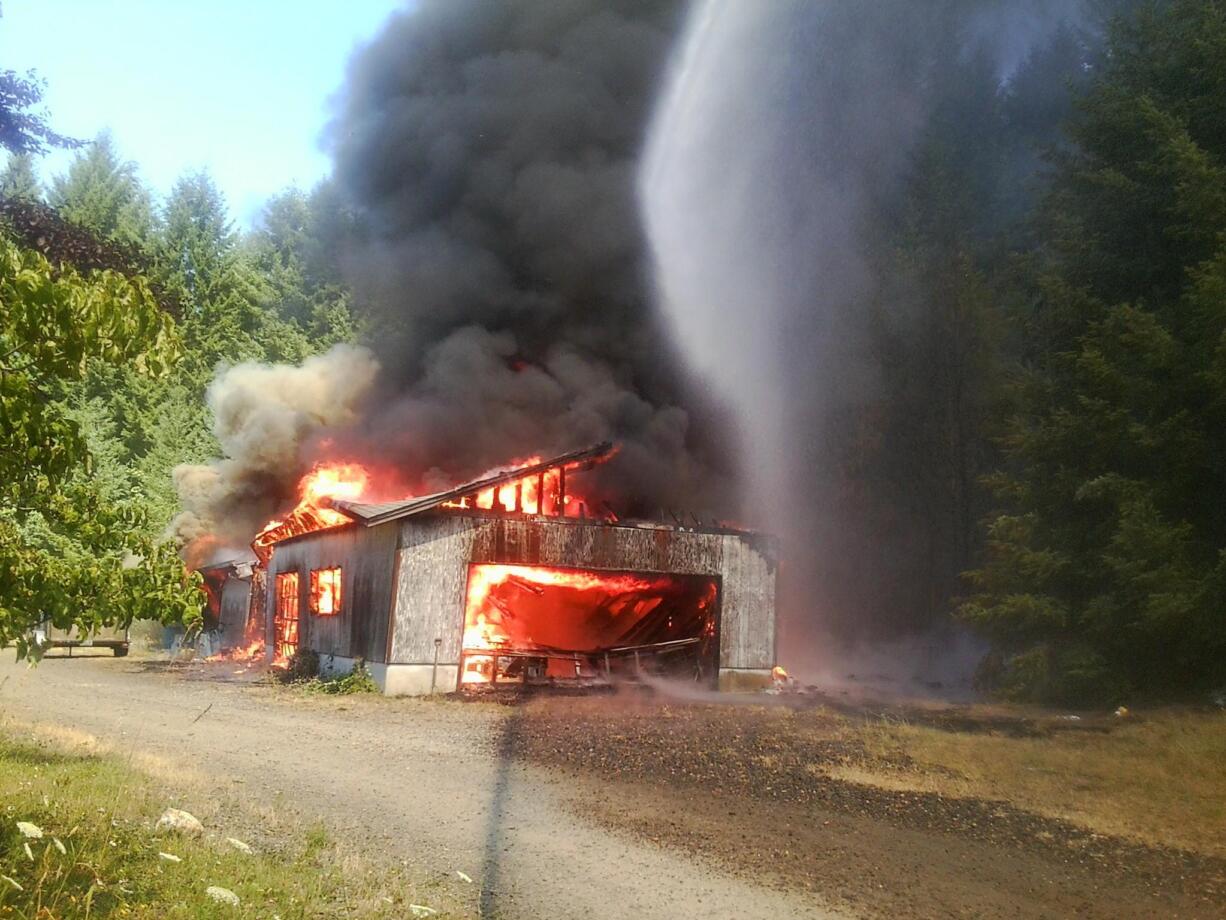 Flames engulf a shop building Friday along Northeast 31st Avenue near 344th Street just east of La Center before firefighters arrived.