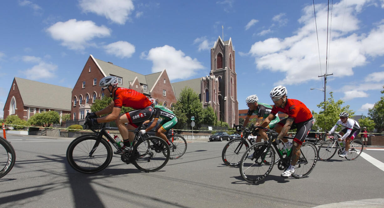 Photos by STEVE DiPAOLA/For The Columbian
Racers in the Category 4 event compete during the Vancouver Courthouse Criterium in downtown Vancouver on Sunday. Nearly 200 riders tested the eight-block, figure-eight course. St. James Catholic Church is in the background.