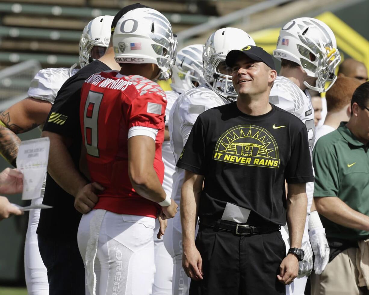 Oregon football coach Mark Helfrich, right, chats with quarterback Marcus Mariota during their spring NCAA college football game in Eugene, Ore. Helfrich has talked to predecessor Chip Kelly a bunch of times since Kelly bolted to the NFL. Kelly's advice? &quot;Be yourself,&quot; Helfrich said. &quot;If I can be known as the guy who kept winning after Chip Kelly, I'm good with that.&quot; The Ducks seemed primed to do so.