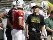 Oregon football coach Mark Helfrich, right, chats with quarterback Marcus Mariota during their spring NCAA college football game in Eugene, Ore. Helfrich has talked to predecessor Chip Kelly a bunch of times since Kelly bolted to the NFL. Kelly's advice? &quot;Be yourself,&quot; Helfrich said. &quot;If I can be known as the guy who kept winning after Chip Kelly, I'm good with that.&quot; The Ducks seemed primed to do so.