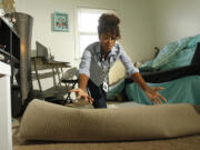 Anyssa Roberts rolls out an Xhilaration Shag Accent Rug from Target, $44, as she shows some interior design techniques.