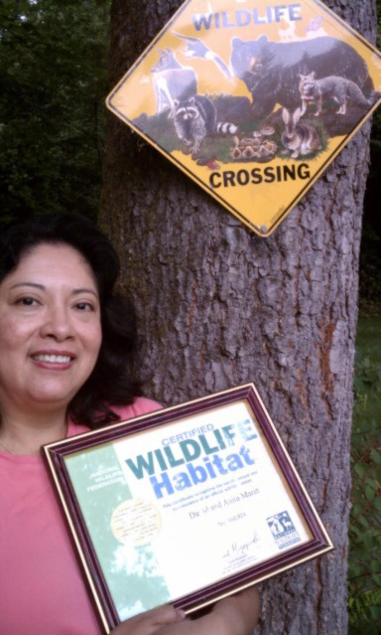 La Center:  Anita Maret shows off the certificate that says her property is going wild.