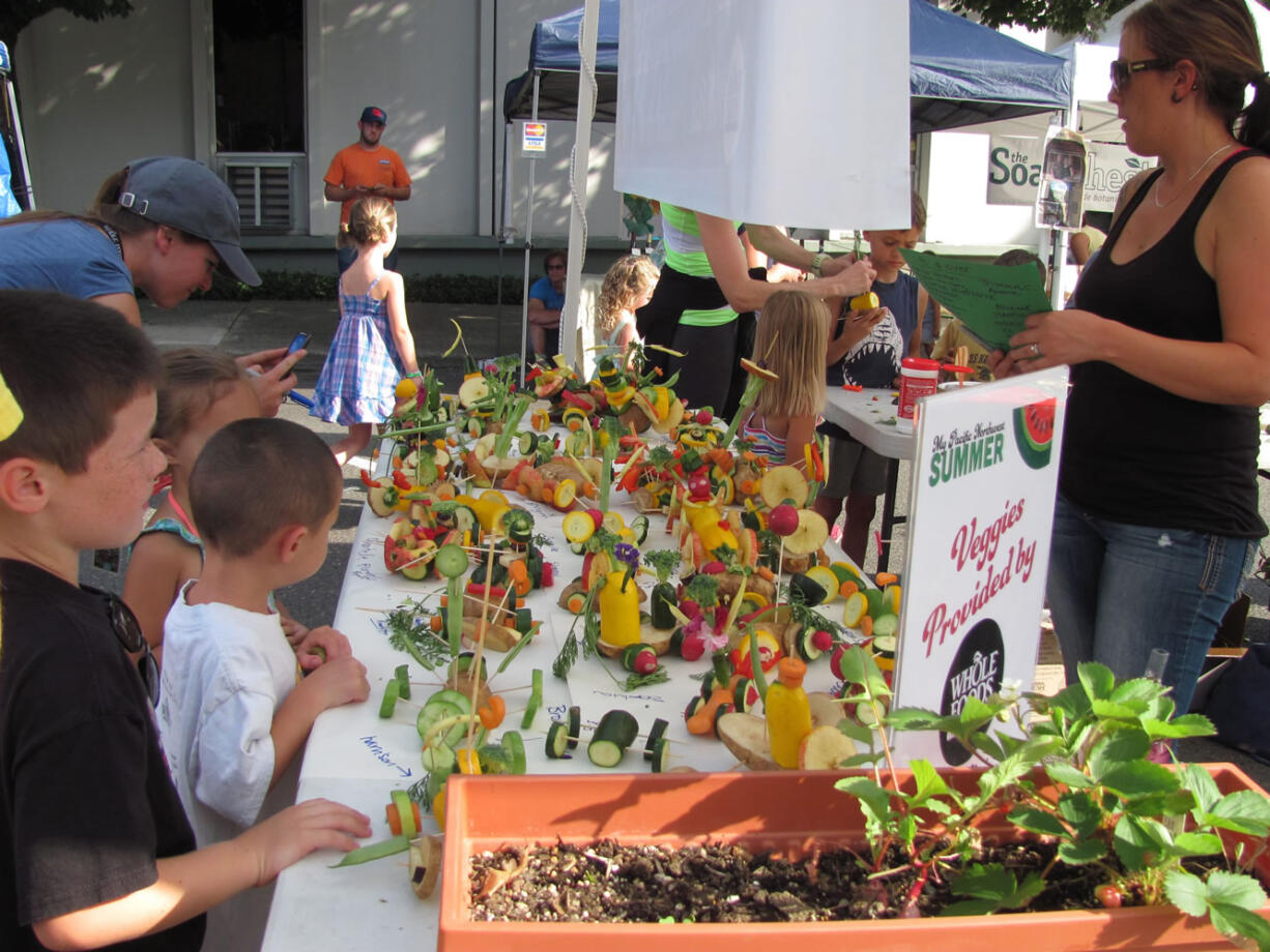 Kids give their creations one final inspection before the Camas Farmer's Market Veggie Derby last Wednesday, while others work on last minute touches.