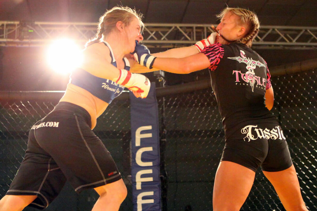 Emily Whitmore (right) throws fists with Liz Tracy during Caged at the Coast 6, in Lincoln City, Ore. Whitmore, who grew up in Washougal, will fight for the FCFF Female 125-pound championship at Rumble at the Roseland 65, Aug.