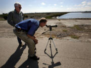 Biologist Peter Bloom watches some newborn burrowing owls on Aug.