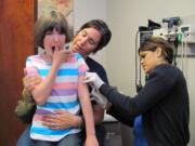 Jill Conley of Washougal gets a chicken pox immunization during a free clinic at Lacamas Medical Group in Camas. Her mom, Bettina Conley, comforts her.