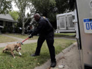 Malachi Jackson, an officer with the City of Detroit Animal Control, takes a pit bull that had bitten someone to be quarantined Monday.