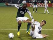 Portland's Franck Songo'o, left, steals the ball from Vancouver Whitecaps defender Jay Demerit during the second half Saturday.